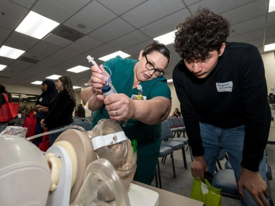 A woman and a man working together on a machine in a room, showcasing their skills and collaboration.